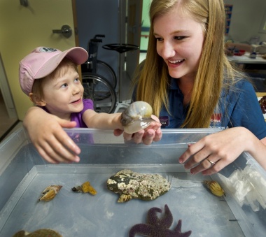 Four-year-old Madeleine Gillingham, a regular patient at the Janeway, shows no fear when it comes to picking up slimy sea snails with Victoria LeShane, a marine interpreter with Memorial's Ocean Sciences Centre (OSC). Due to ongoing construction at the research facility in Logy Bay, the OSC's Marine Public Education Program is travelling with its touch tank around the capital city all summer long. Other locations include the Fluvarium at Pippy Park and the MUN Botanical Garden. Contact Danielle Nichols at 709-864-2459 for more information.